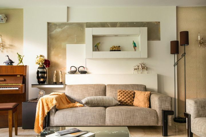 Four-poster bed with a studio couch, quilt, bookcase, and entertainment center in a cozy living space.