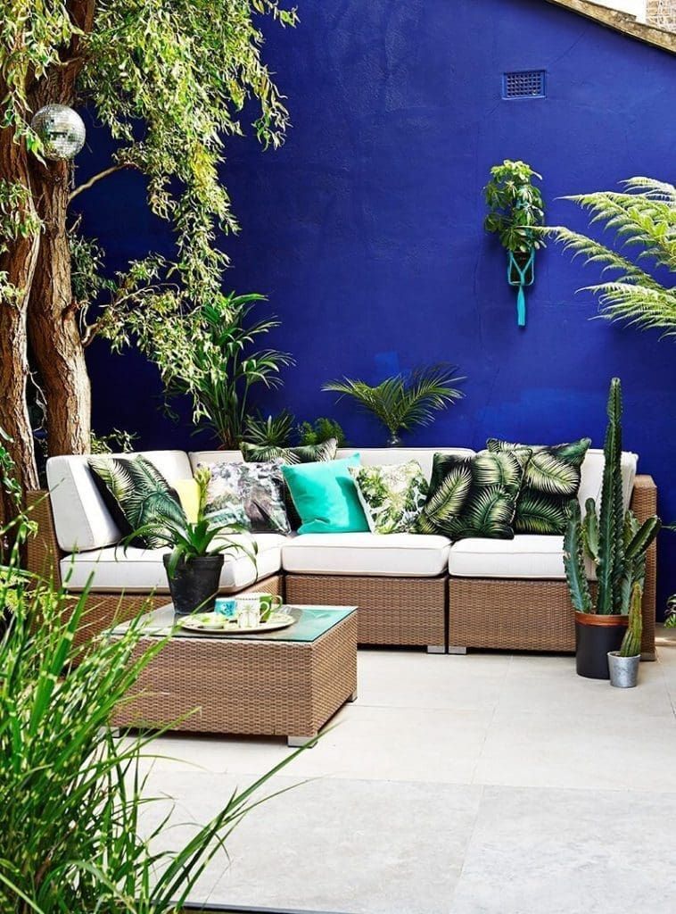 A backyard with chairs and blue painted fence