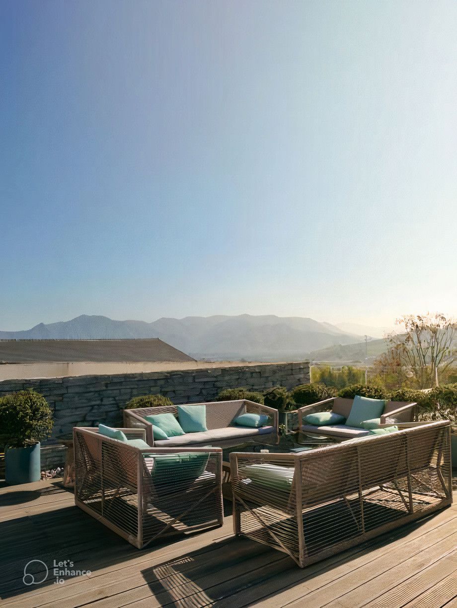 A patio with a lot of furniture and a view of the mountains.