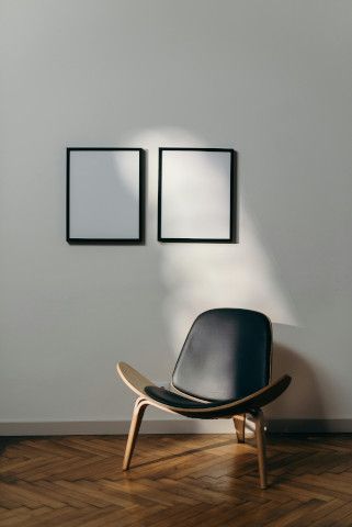 Lampshade above a dining table with a rocking chair, table lamp, and wall clock.