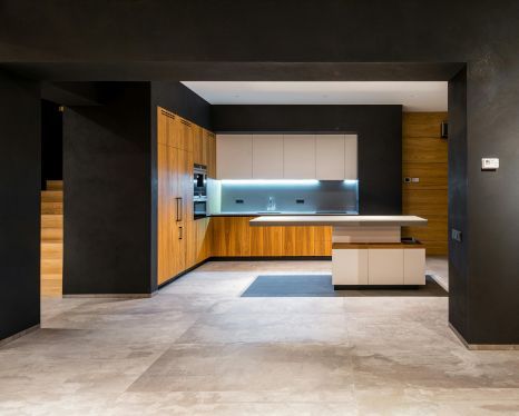 A kitchen with wooden cabinets and a large island in the middle.