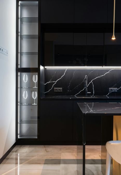 A kitchen with black cabinets and marble counter tops