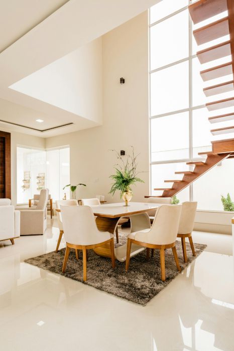 A living room with a dining table and chairs and stairs. Staircase expertly varnished by Foxglove Decor in Sunderland.