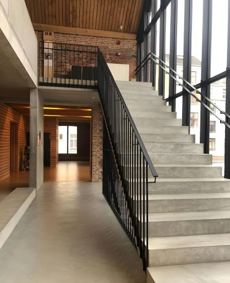 A staircase in a building with lots of windows. Staircase expertly painted by Foxglove Decor in Sunderland, UK.