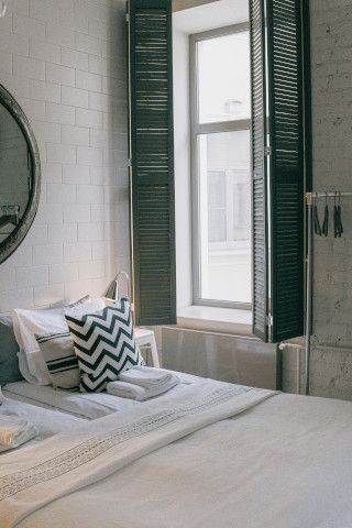 Sliding door leading to a studio couch, window shade, and doormat near a patio.