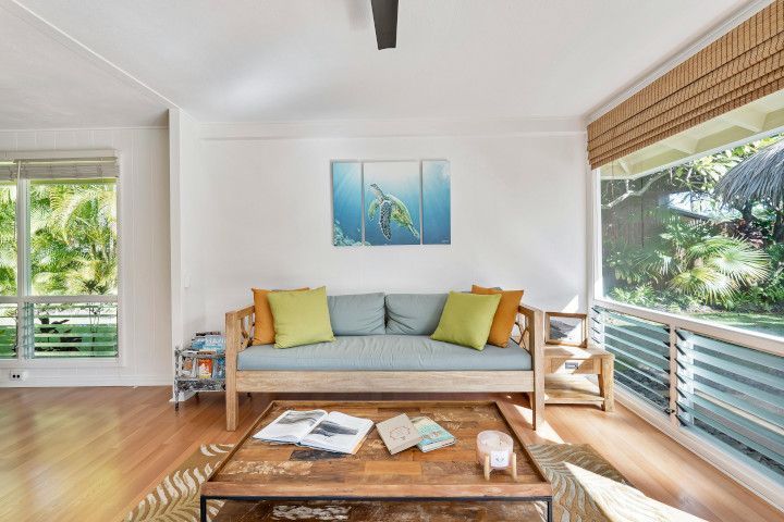 Studio couch near a window shade, four-poster bed, patio, and rocking chair.