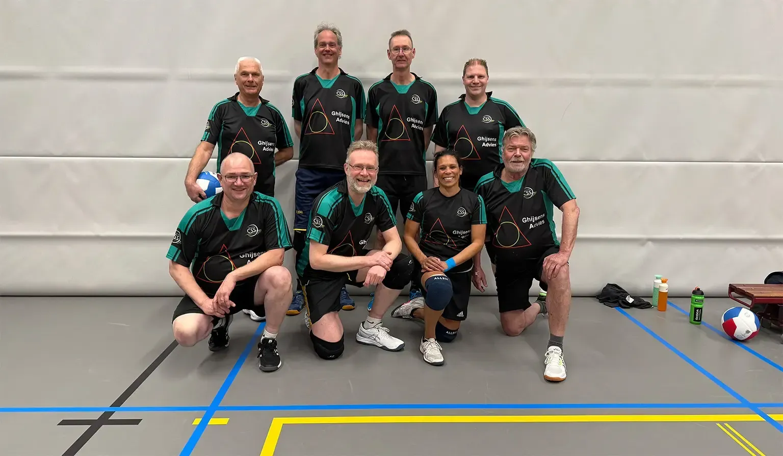 Een groep mensen poseert voor een foto in een sportschool.