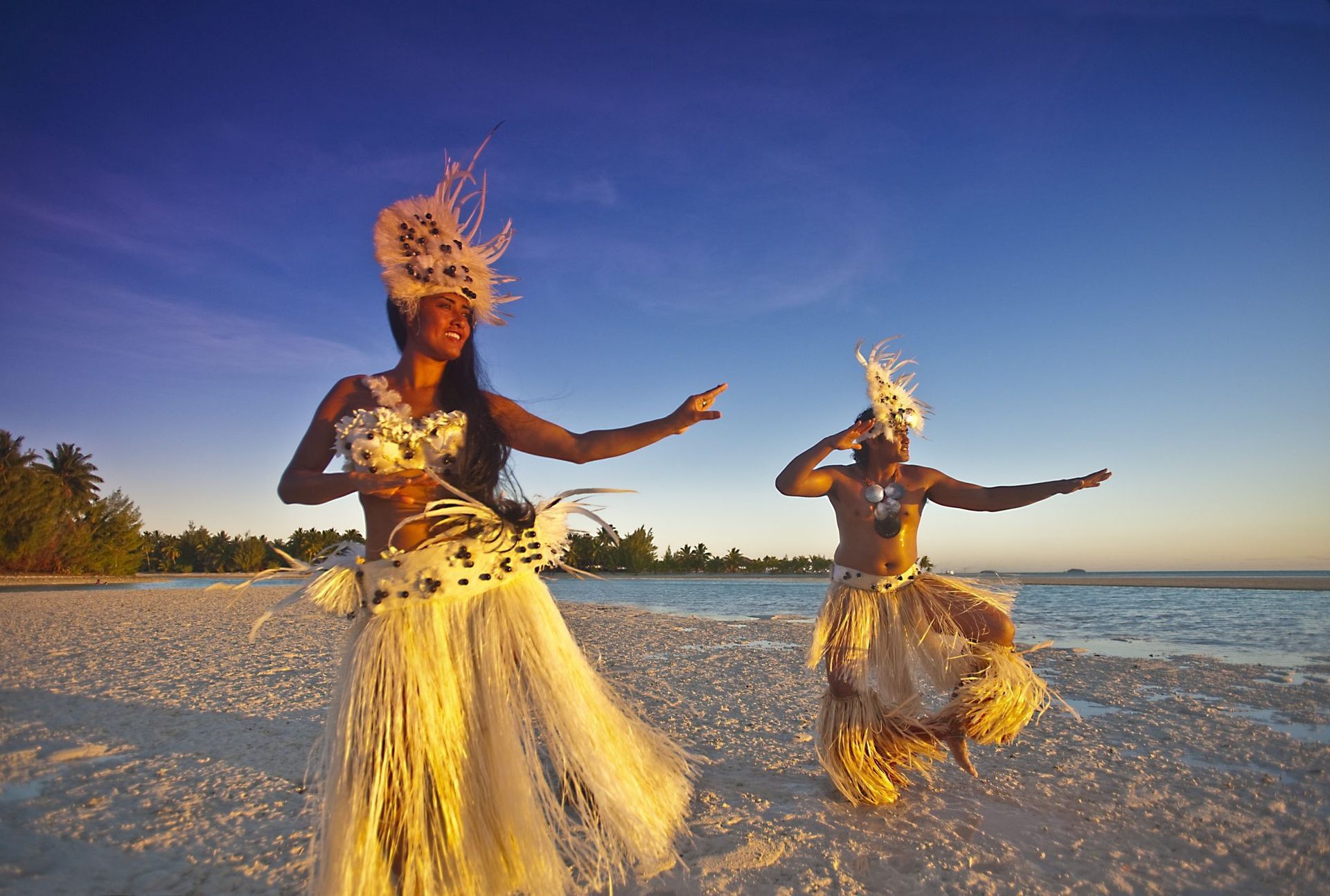 a man and a woman are dancing on a beach .