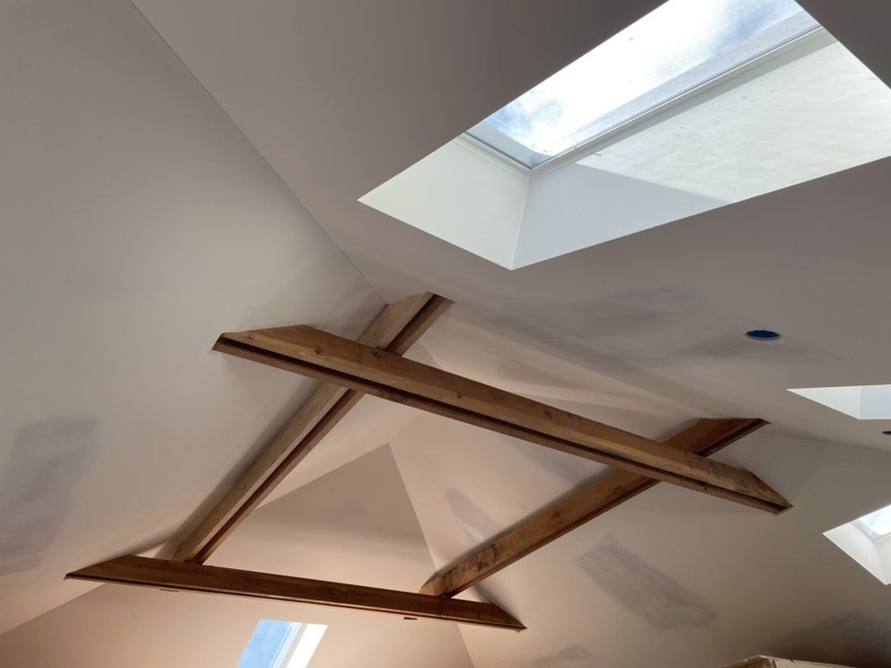 A man is working on a ceiling with a drill.