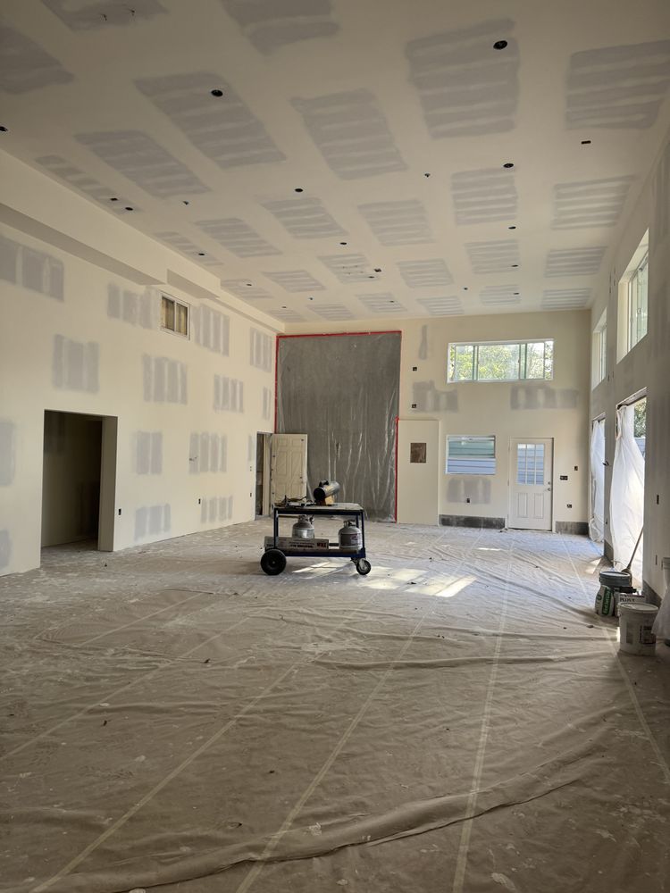 An empty room in a house under construction with drywall on the walls.