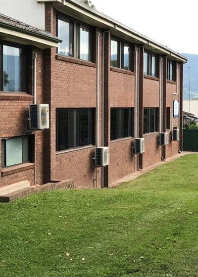 Air Conditioner On Brick School Building — Steve’s Air Conditioning in Shellharbour, NSW