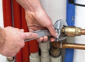 using a wrench to tighten a bolt on a water tank