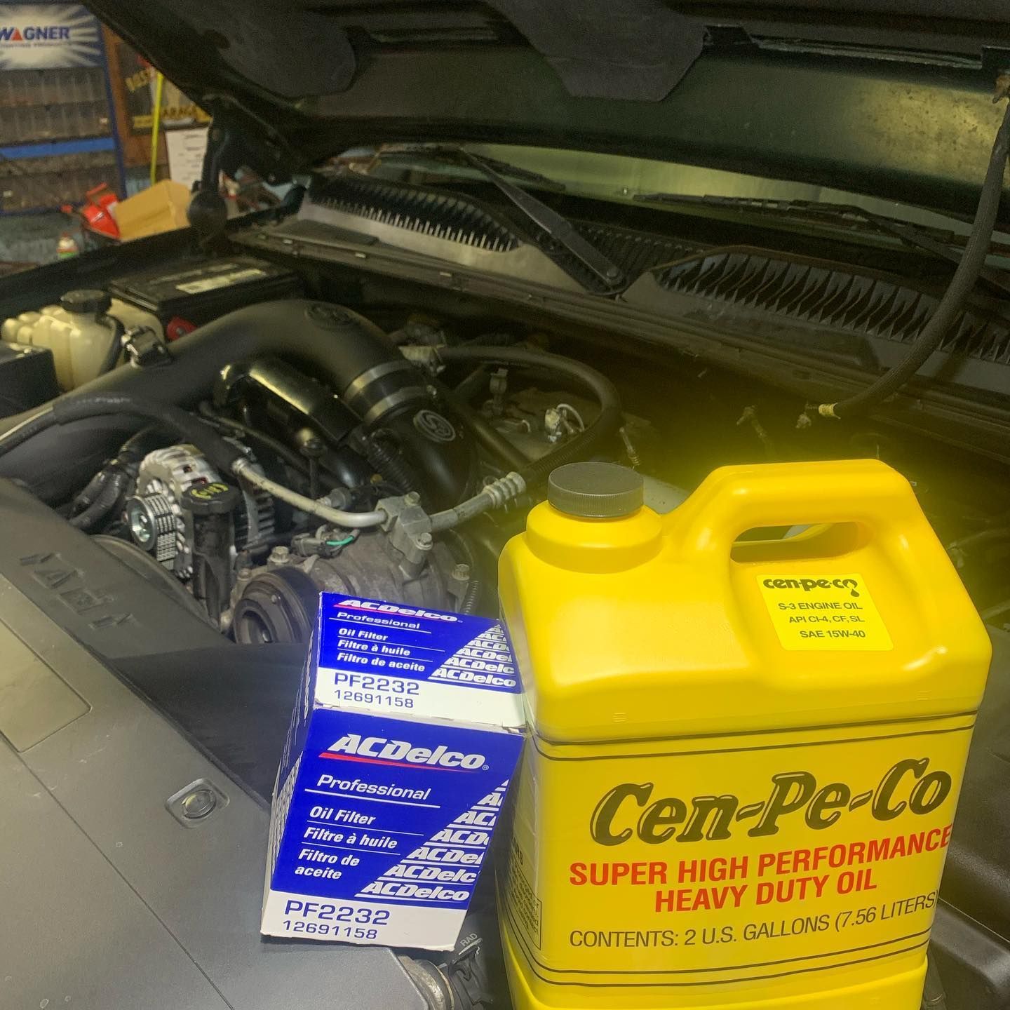 Truck engine bay with oil and filter; maintenance is in progress.