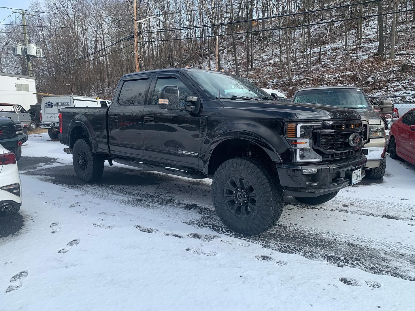 Black Ford truck parked in snow.