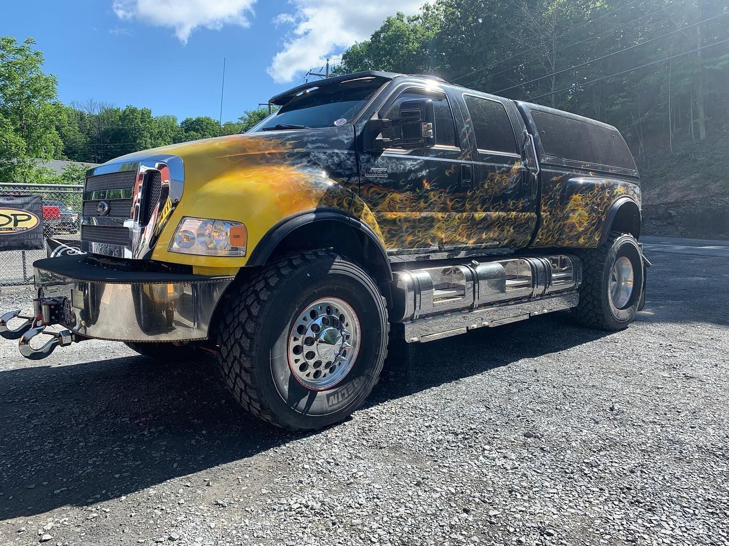 Yellow and black custom Ford truck on gravel. Chrome accents, large tires, and sun visor. Yellow and black custom Ford truck on gravel. Chrome accents, large tires, and sun visor.