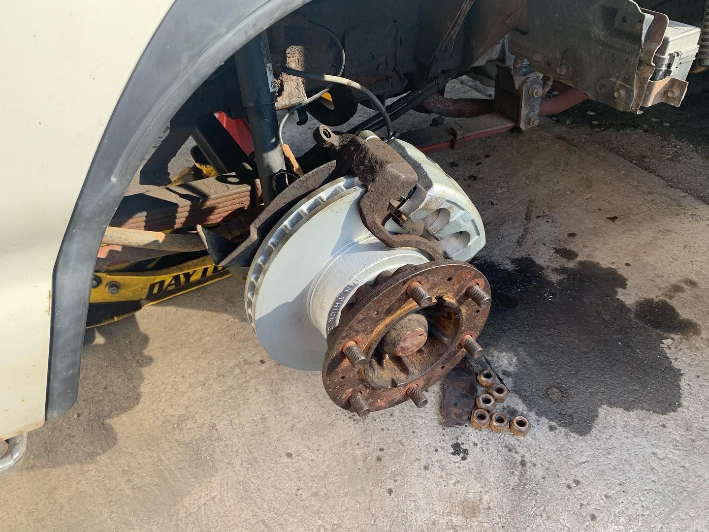 Car wheel with brake components removed, showing a rusty brake rotor and caliper.