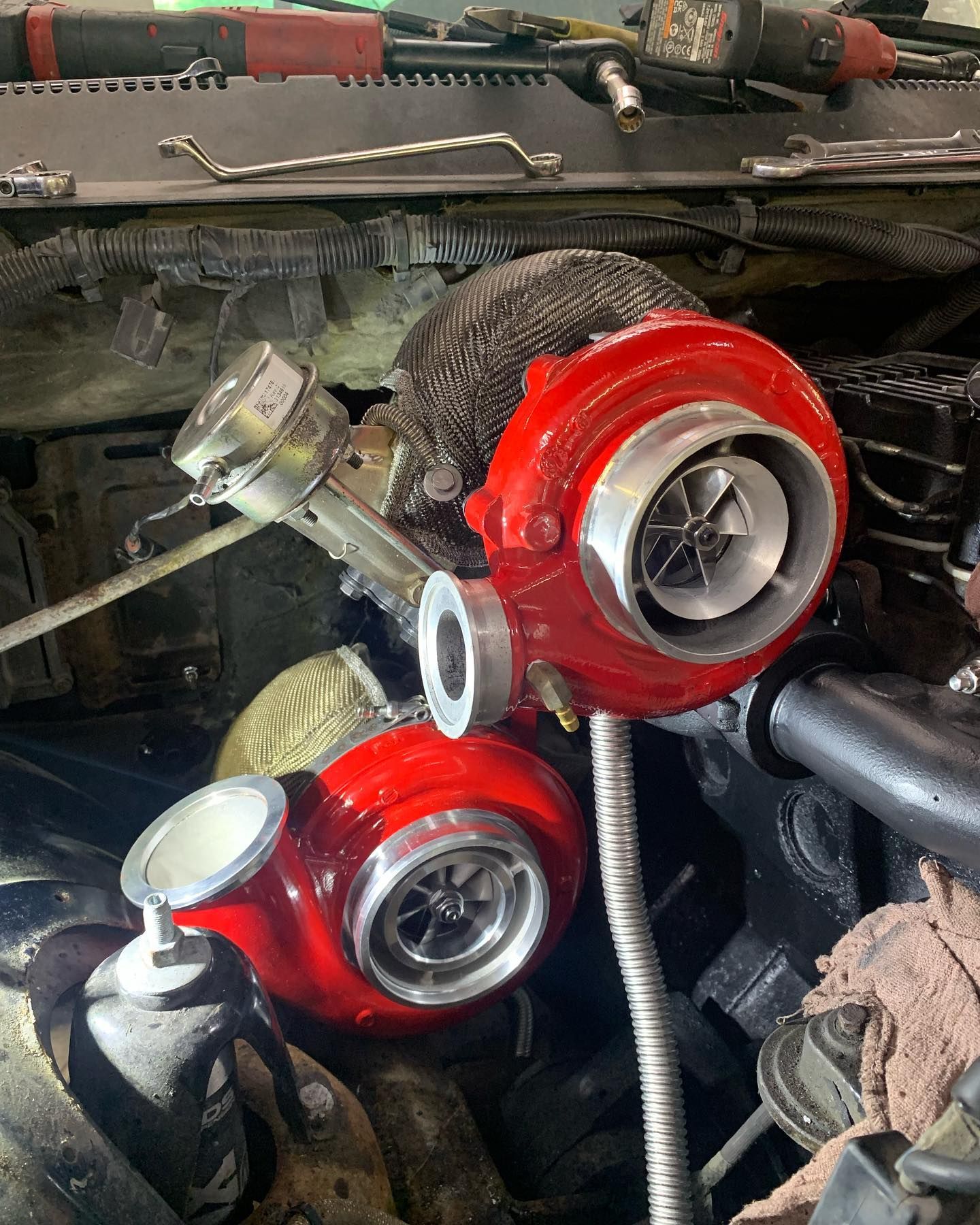Two red turbochargers installed in an engine bay.