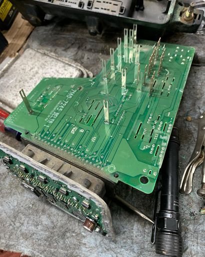 Green circuit board with pins, next to a small circuit board and a flashlight. Green circuit board with pins, next to a small circuit board and a flashlight.