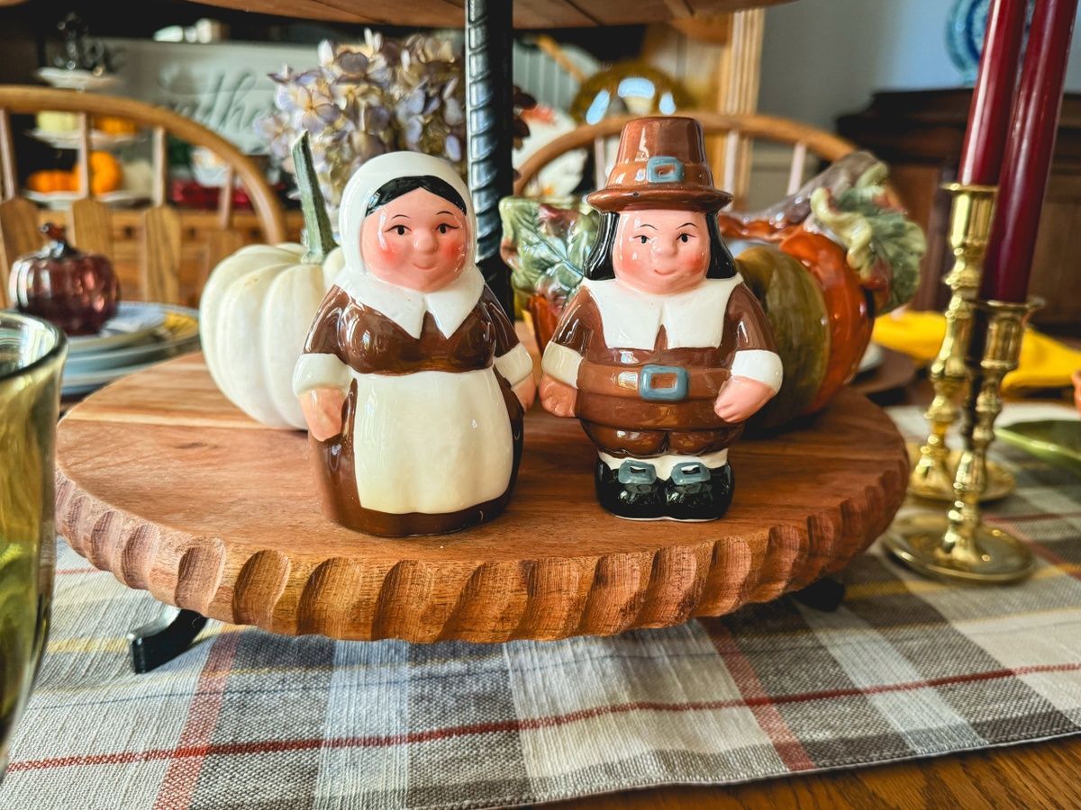 A couple of salt and pepper shakers sitting on top of a wooden tray on a table.