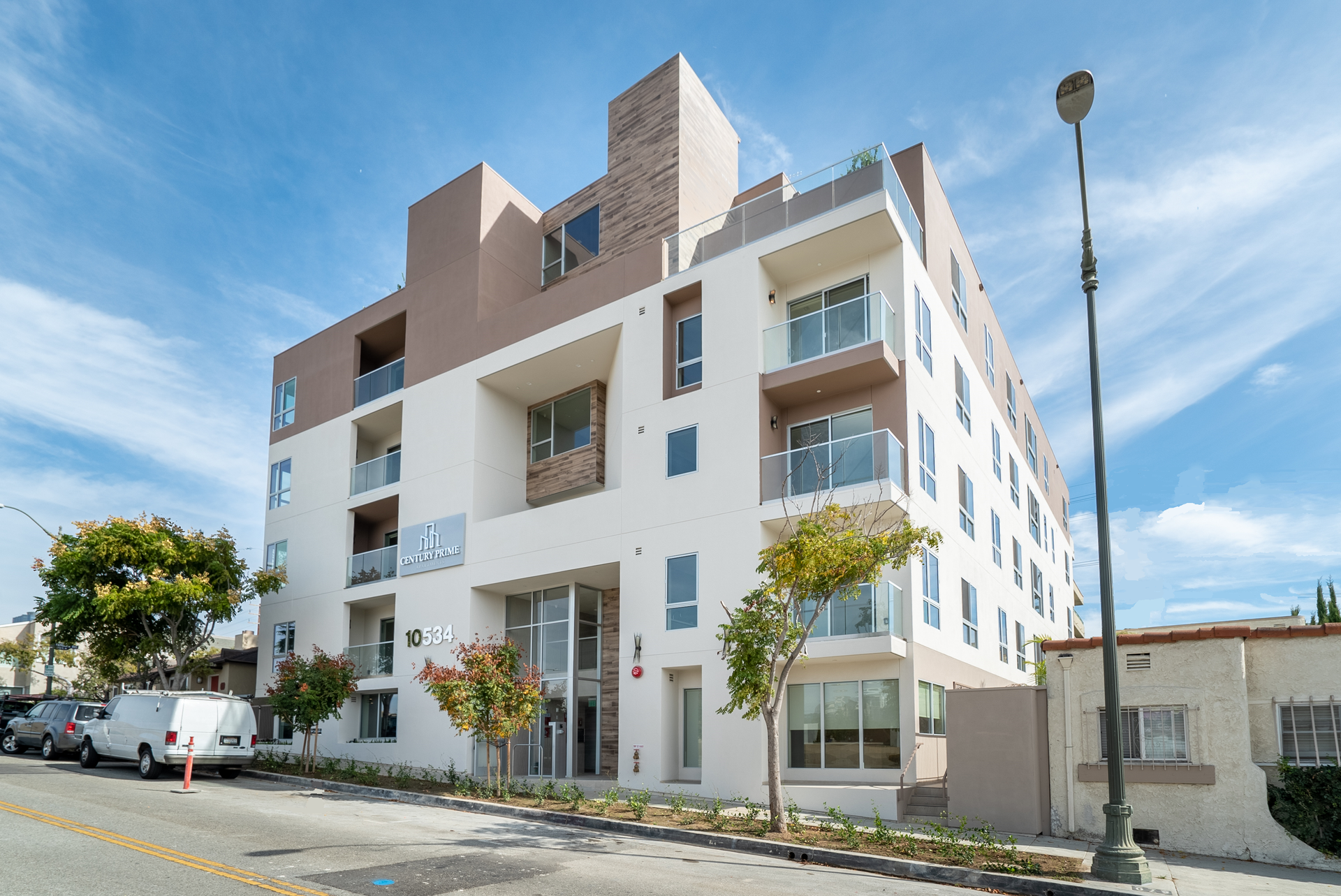 Modern apartment building with beige and white facade under a blue sky.