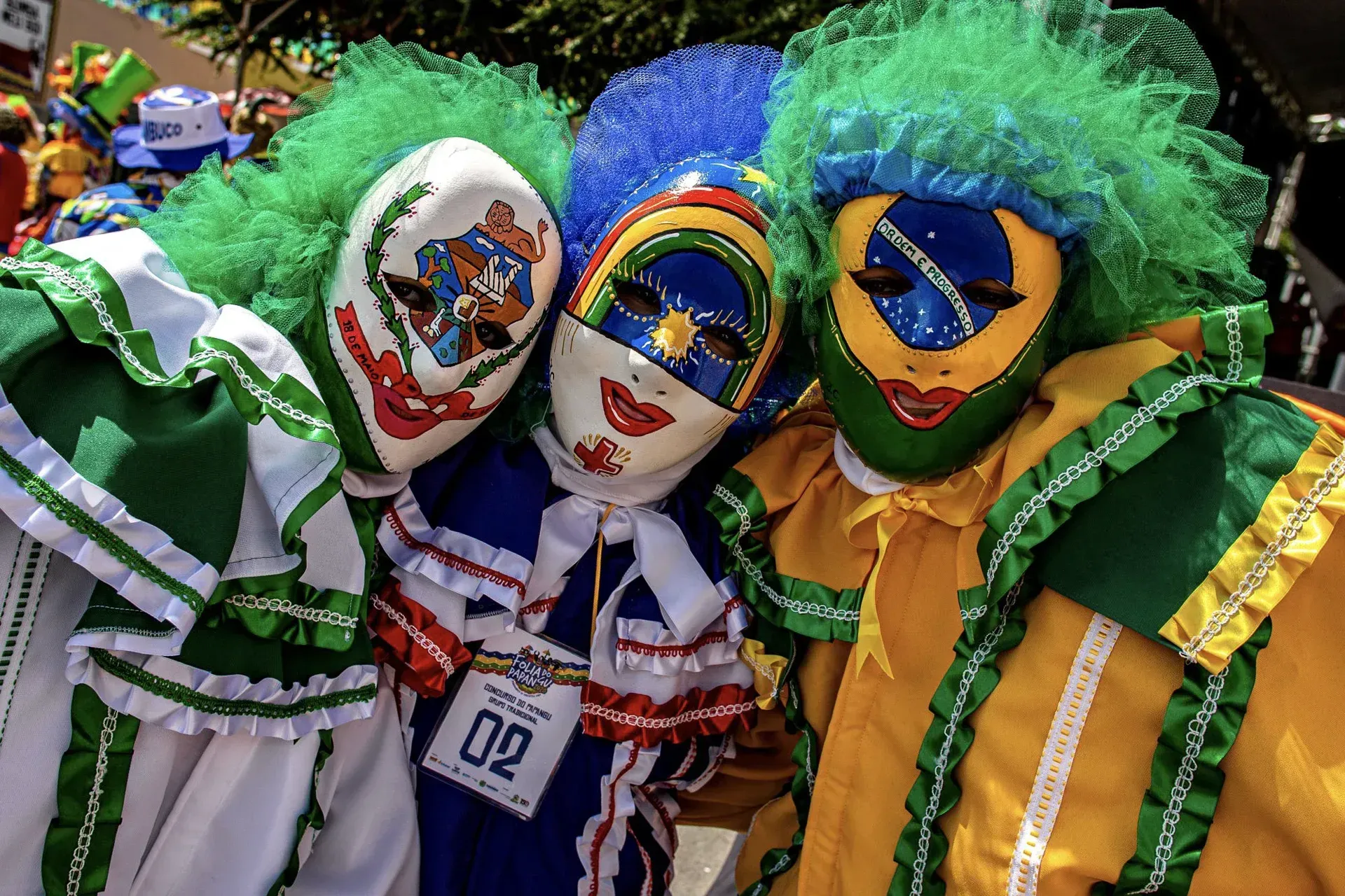 Três palhaços estão posando para uma foto, um deles usando uma etiqueta que diz 02