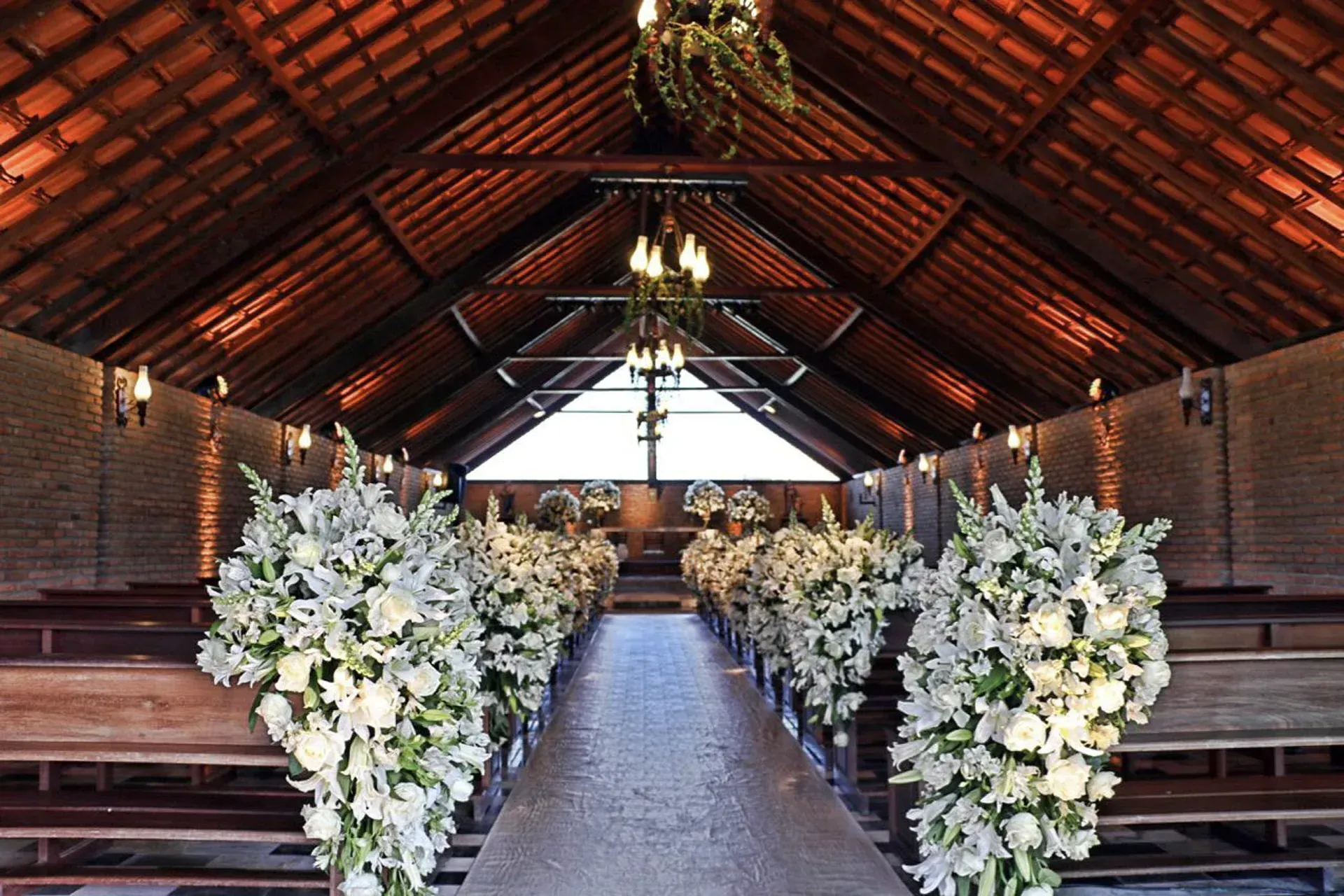 Uma igreja com fileiras de flores brancas no corredor