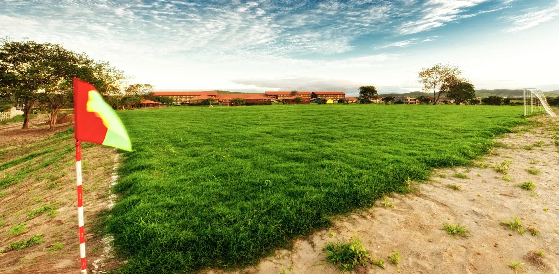 Um campo verde com uma bandeira vermelha e amarela no meio.