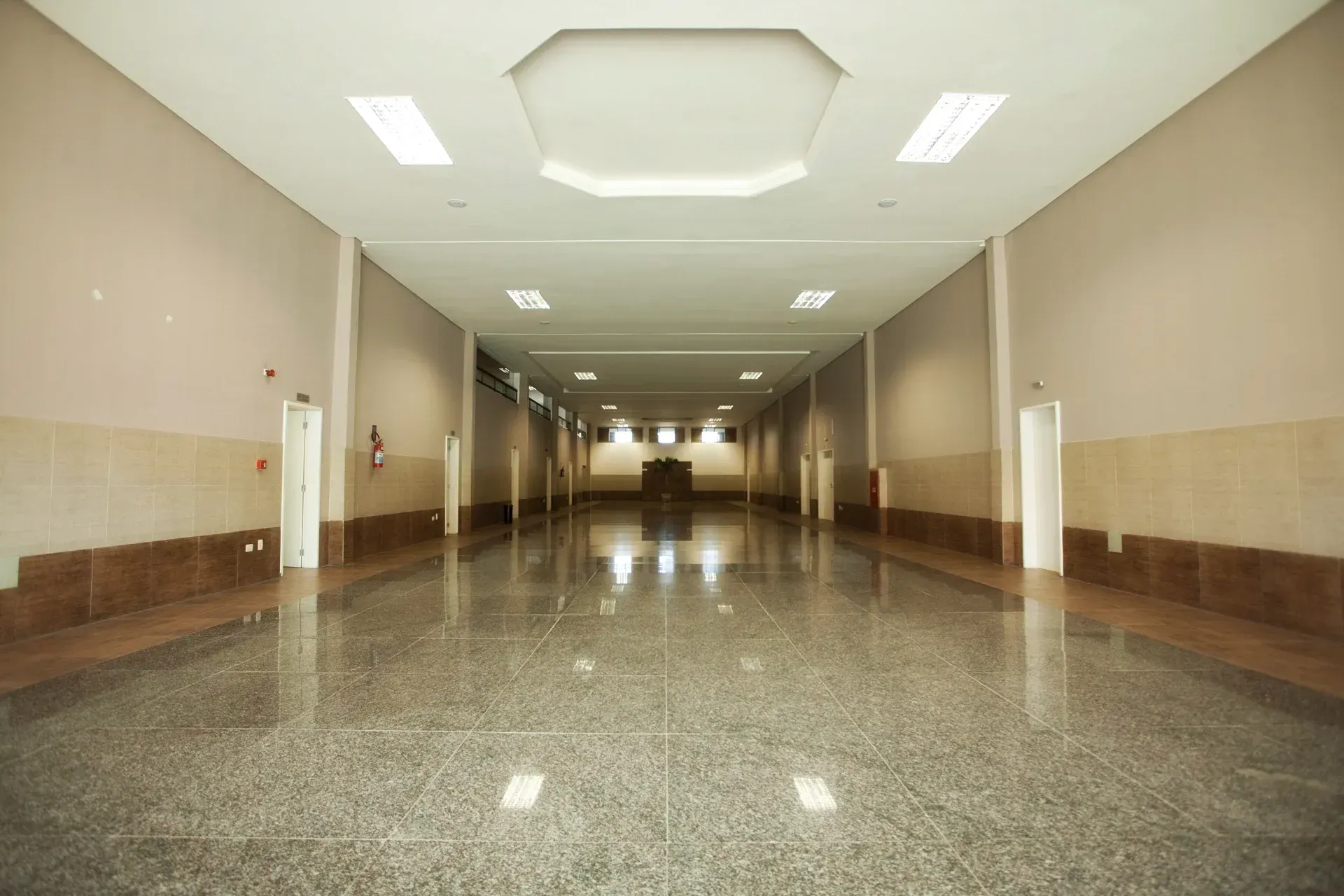 Um corredor vazio com piso e paredes de mármore