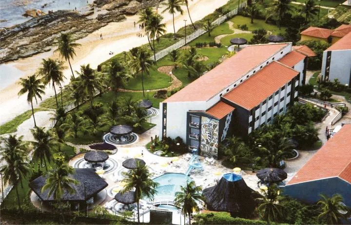 Uma vista aérea de uma praia com muitas cadeiras azuis.