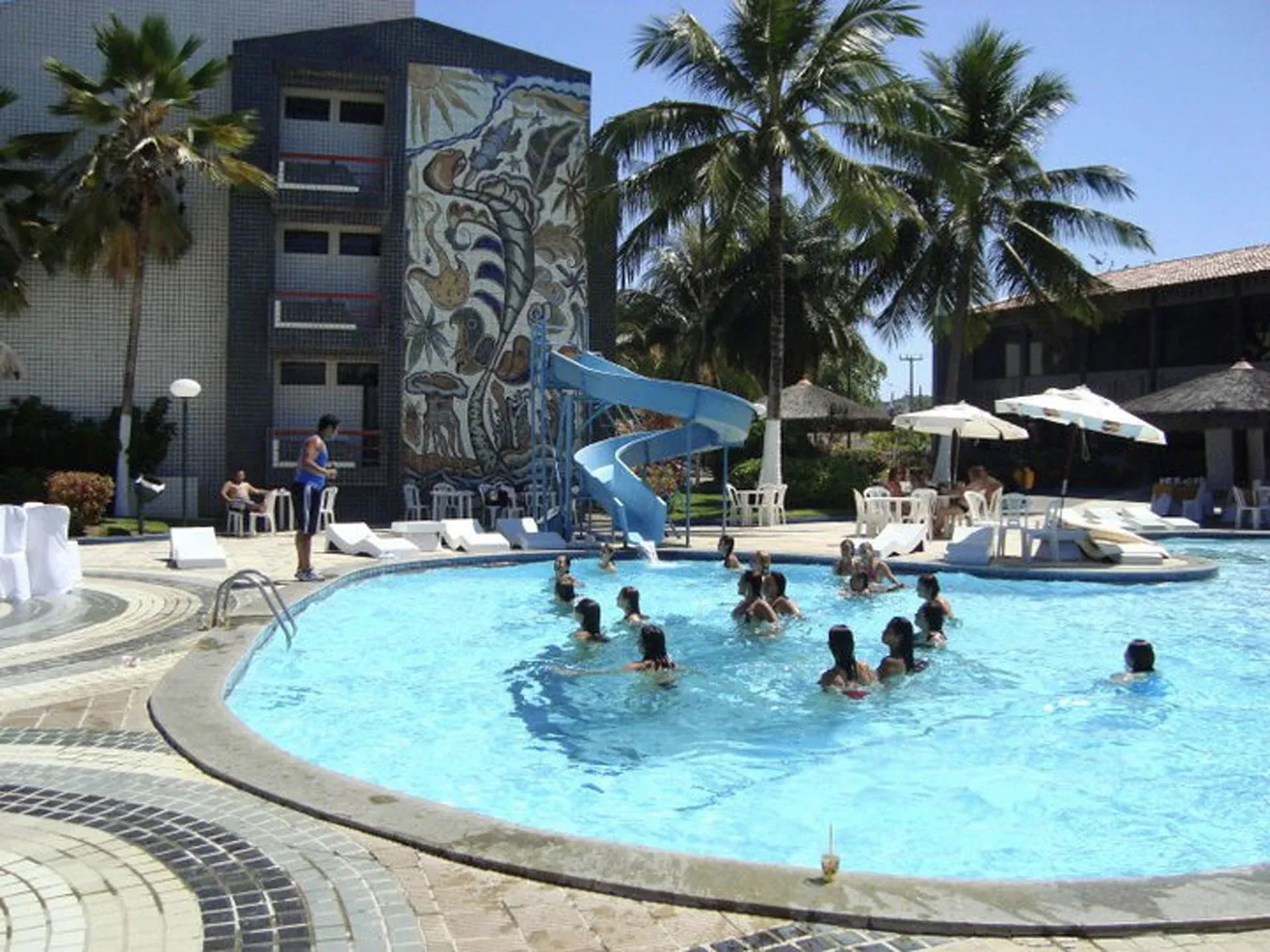 Uma grande piscina com escorregador e mesa