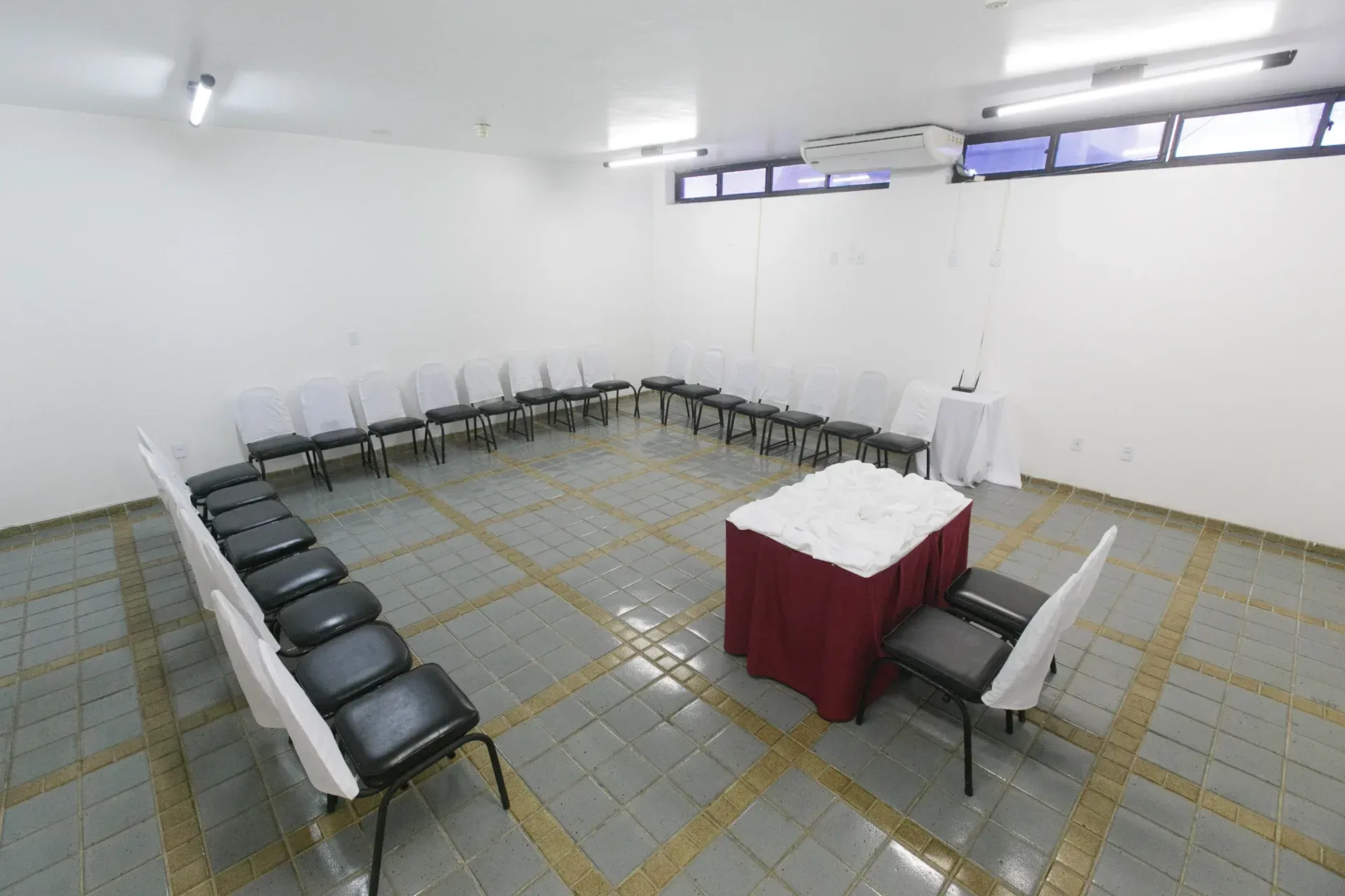 Uma sala com uma mesa e cadeiras em círculo