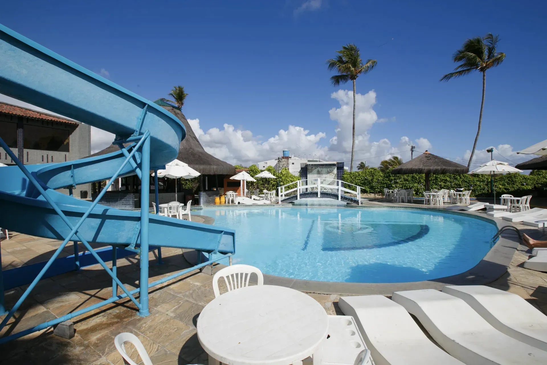 Uma grande piscina com escorregador e mesa
