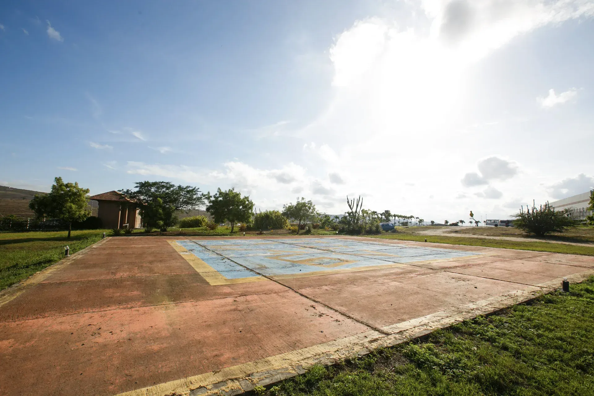 Uma quadra de basquete em um parque com uma casa ao fundo