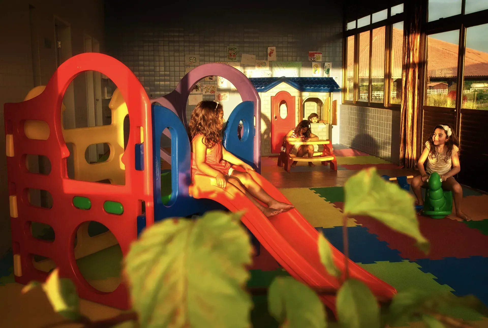 Um grupo de crianças está brincando em um playground com escorregador.