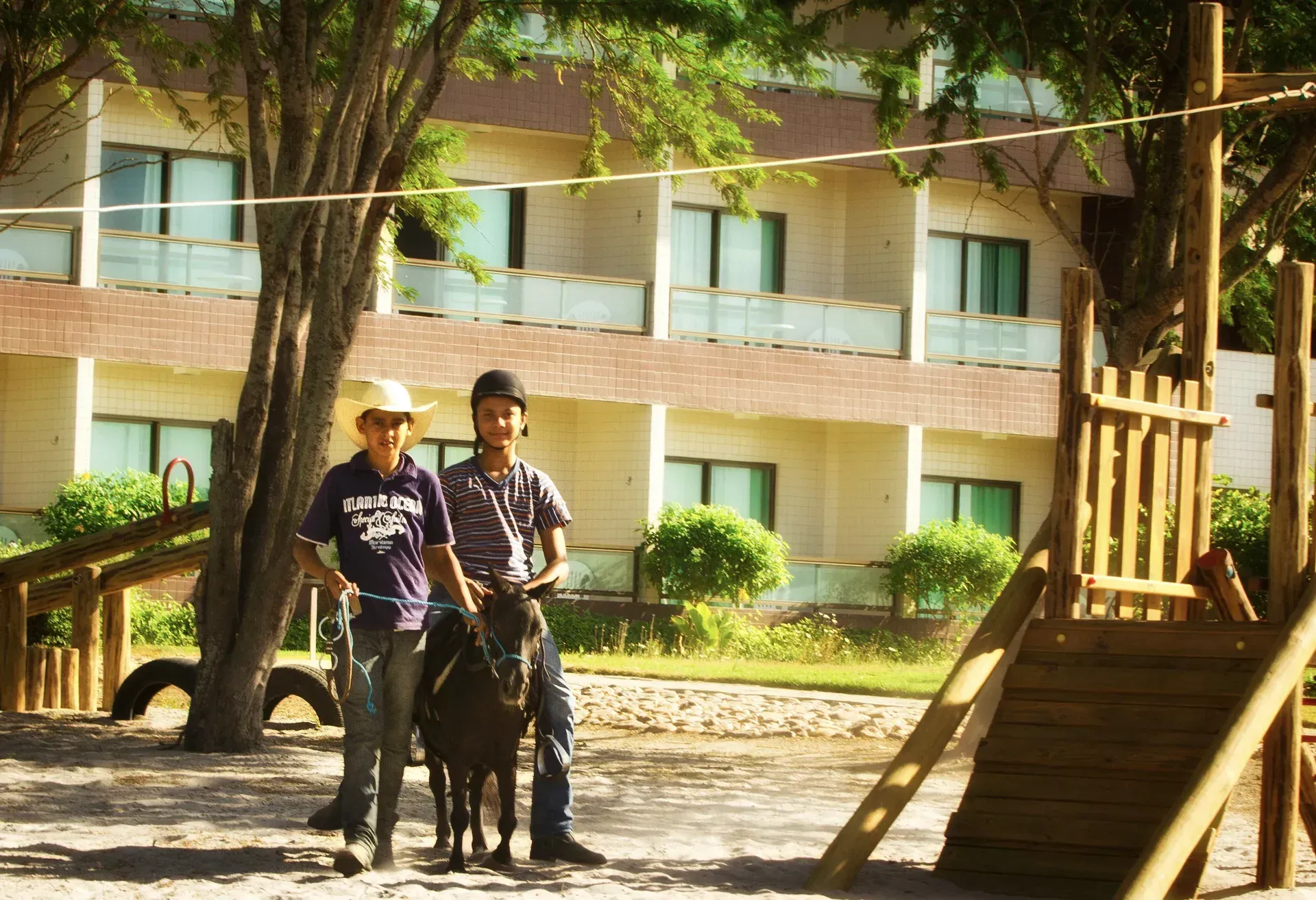 Dois homens cavalgando em frente a um prédio