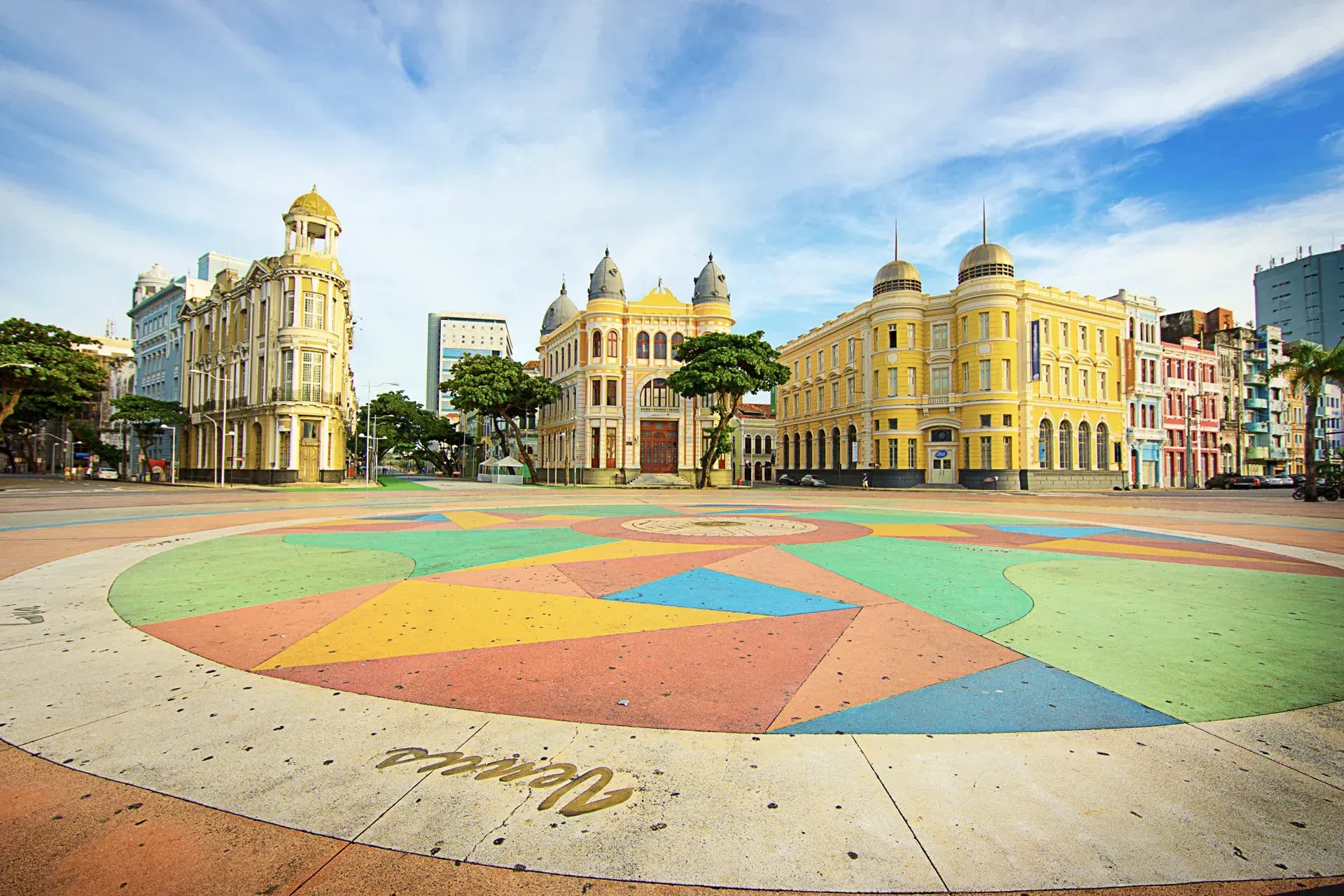Um círculo colorido no meio de uma cidade com edifícios ao fundo