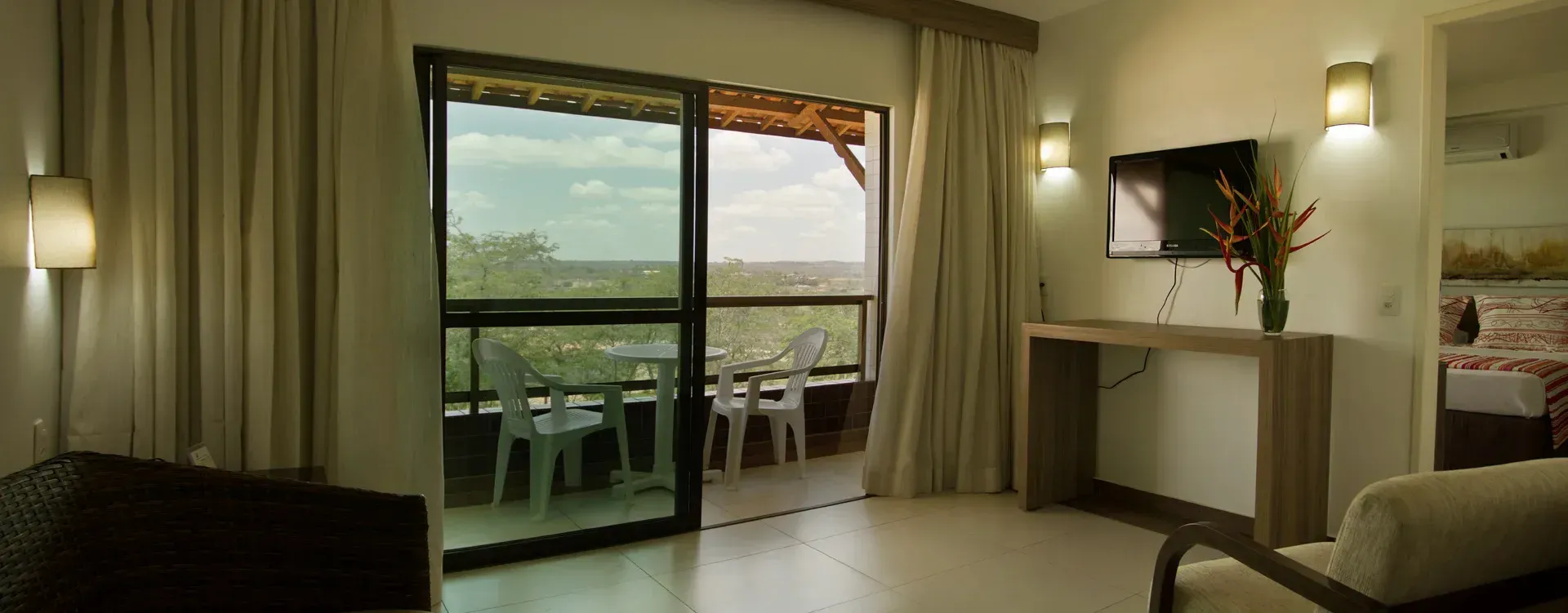 Uma sala de estar com uma porta de vidro deslizante que leva a uma varanda.