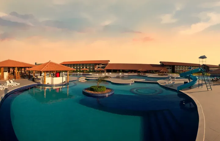 Uma grande piscina com guarda-sóis e cadeiras ao redor