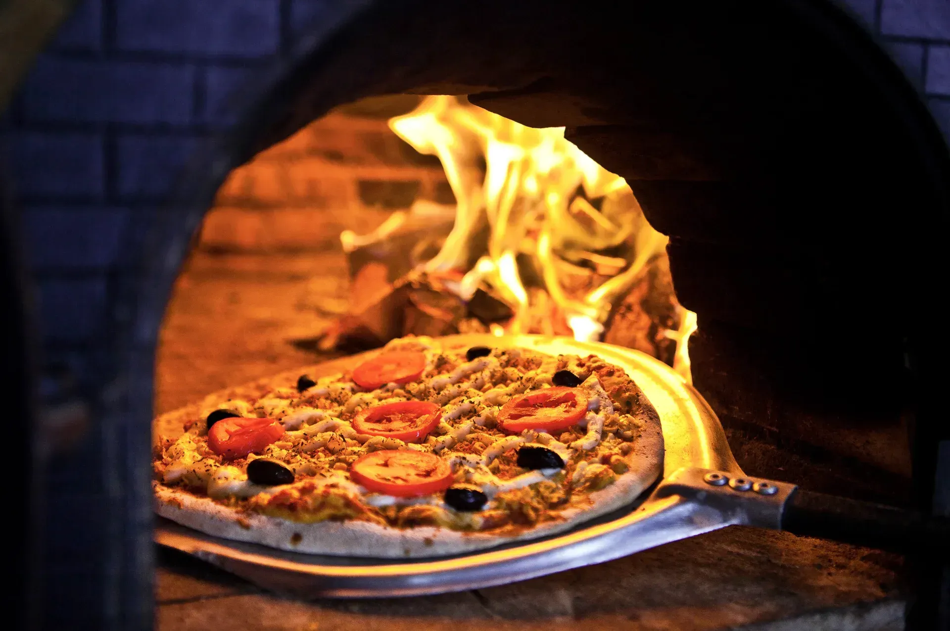 Uma pizza está sendo assada em um forno de tijolos.