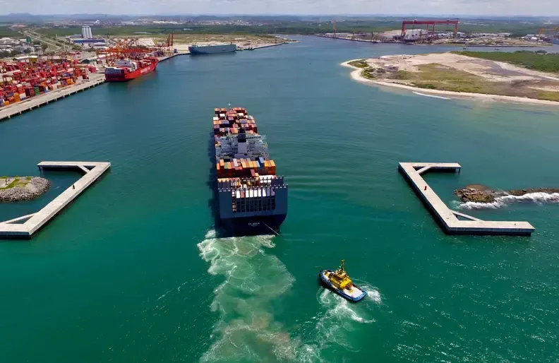 Uma vista aérea de um grande navio porta-contêineres em um porto.