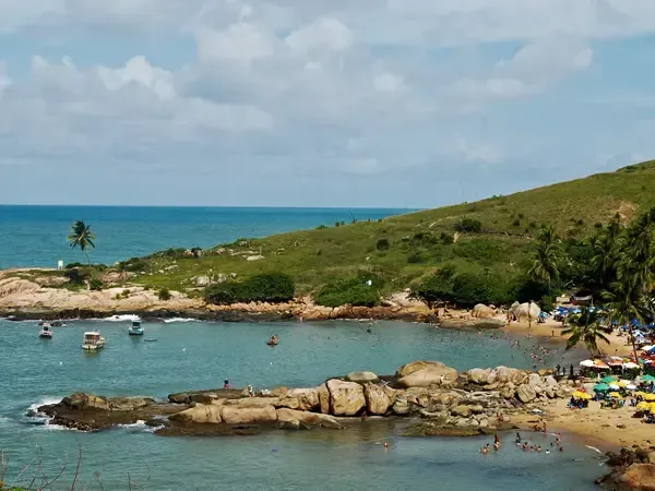 Um grande corpo de água cercado por rochas e uma praia.