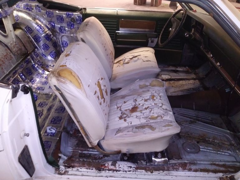 Burned car interior with melted white seats and charred floor