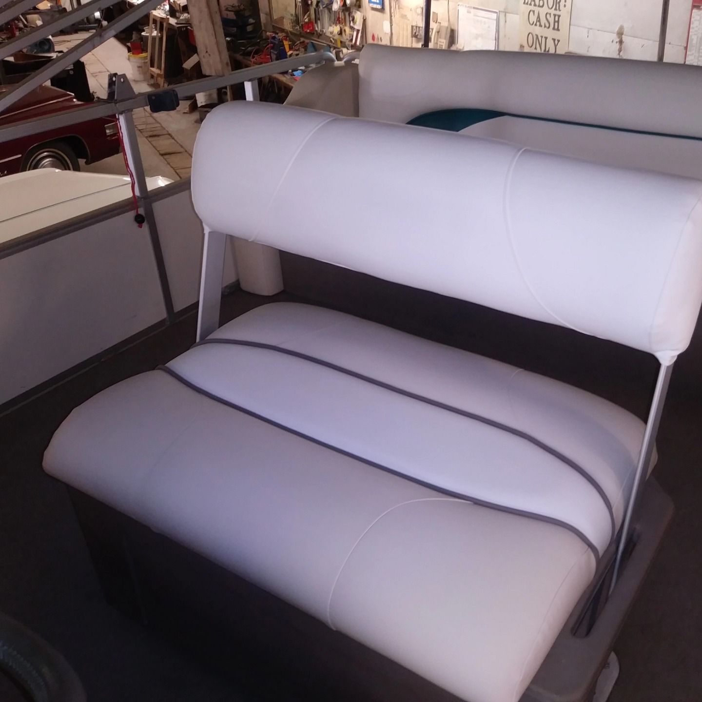 White cushioned bench seat with metal frame in a showroom or showroom-like setting