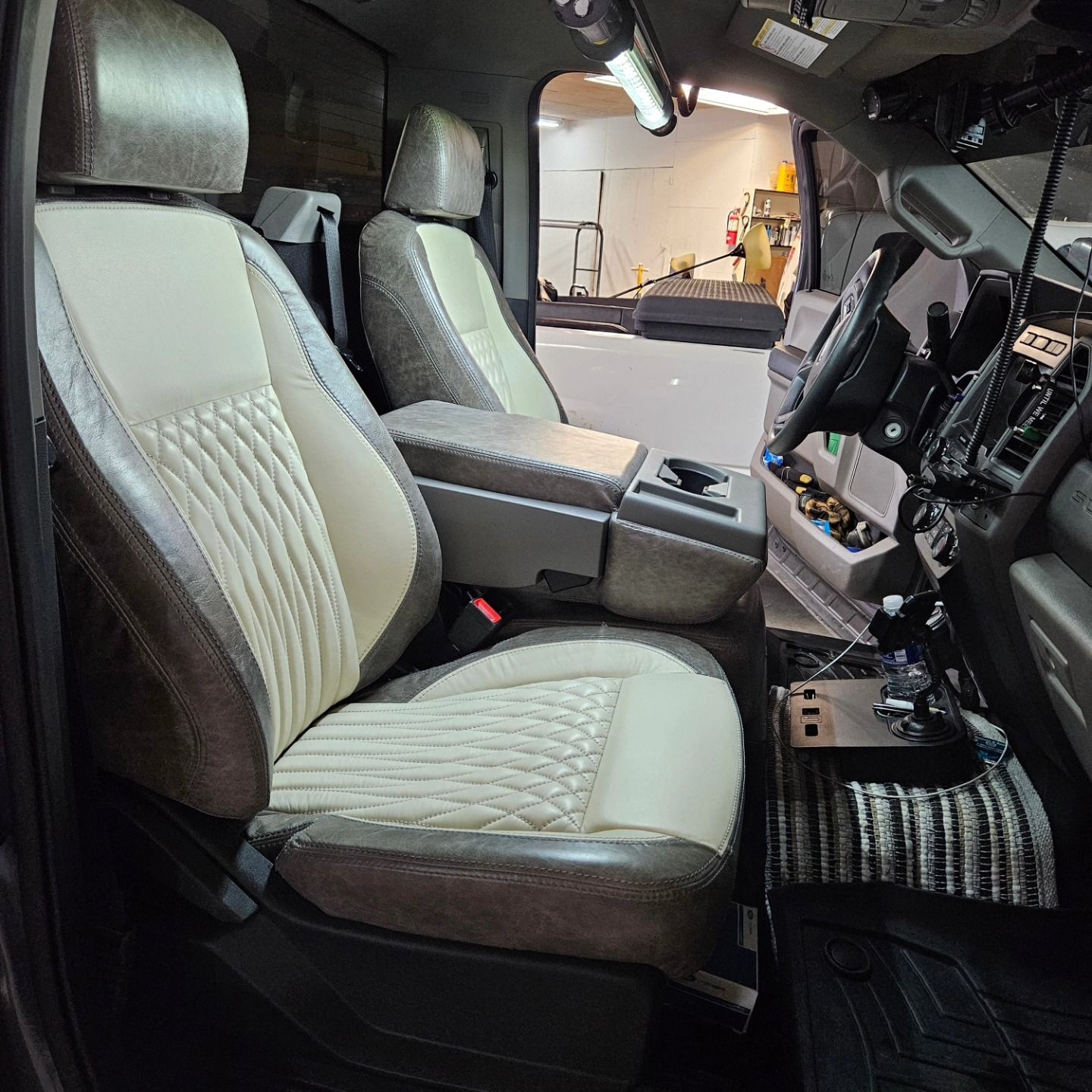 Luxury car interior with cream leather front seats and a black dashboard.