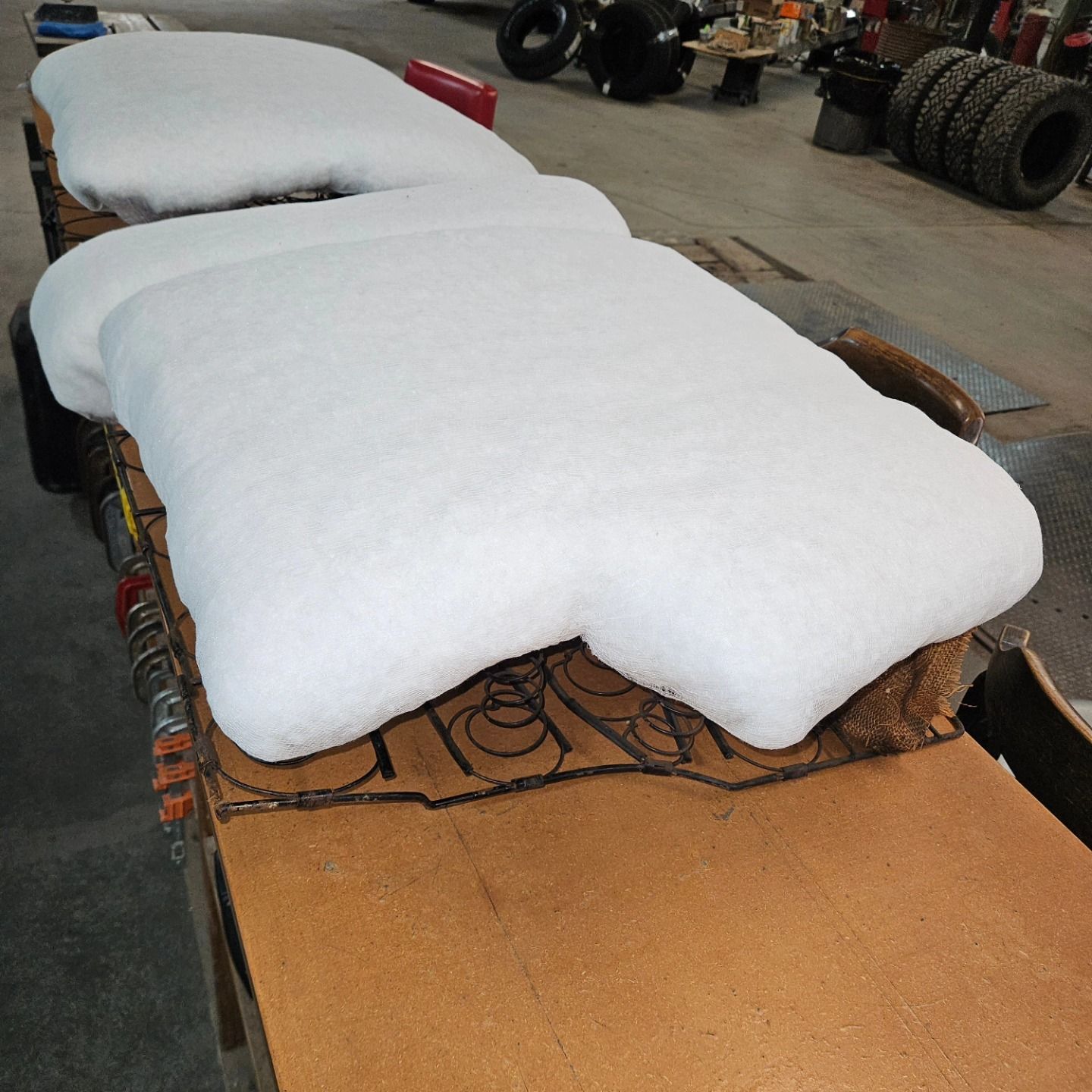 Snow-covered vehicle chassis indoors, with large white snow piles on the seats and front section