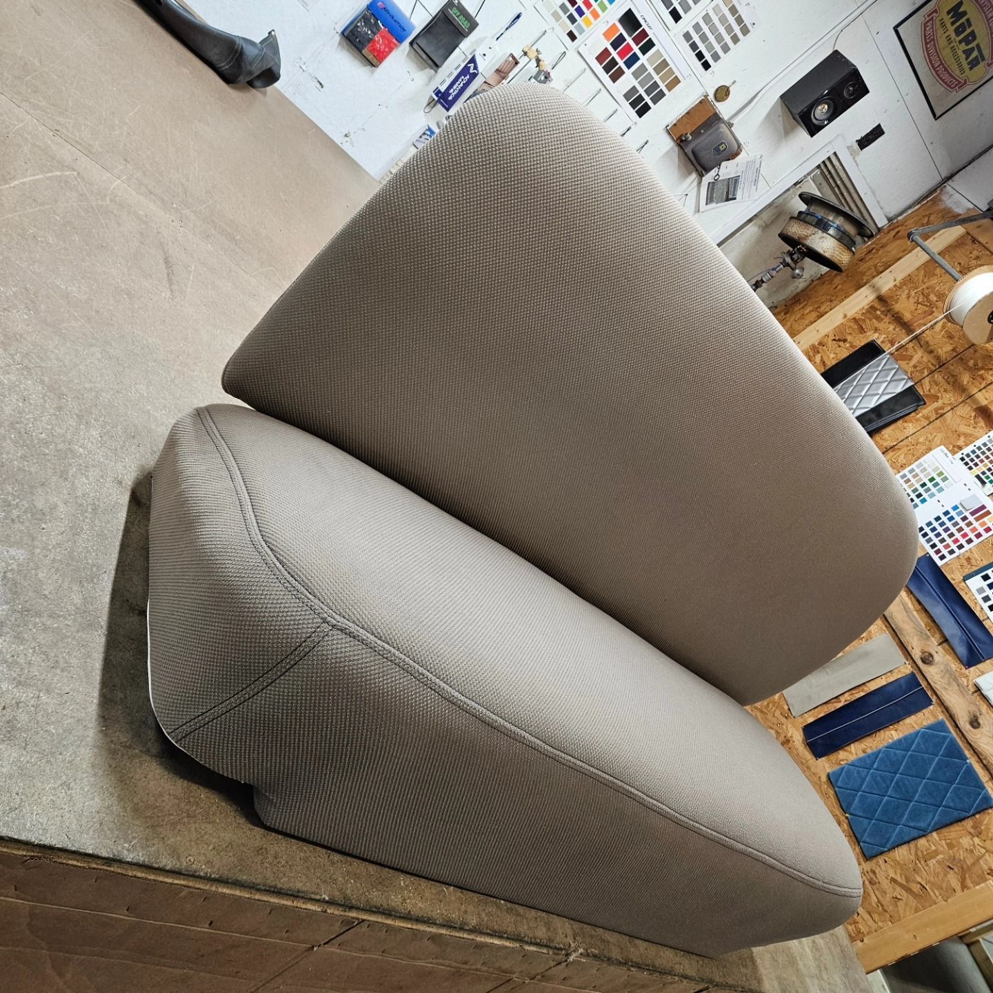 Gray upholstered chair in a furniture showroom, viewed at an angle on carpeted floor.