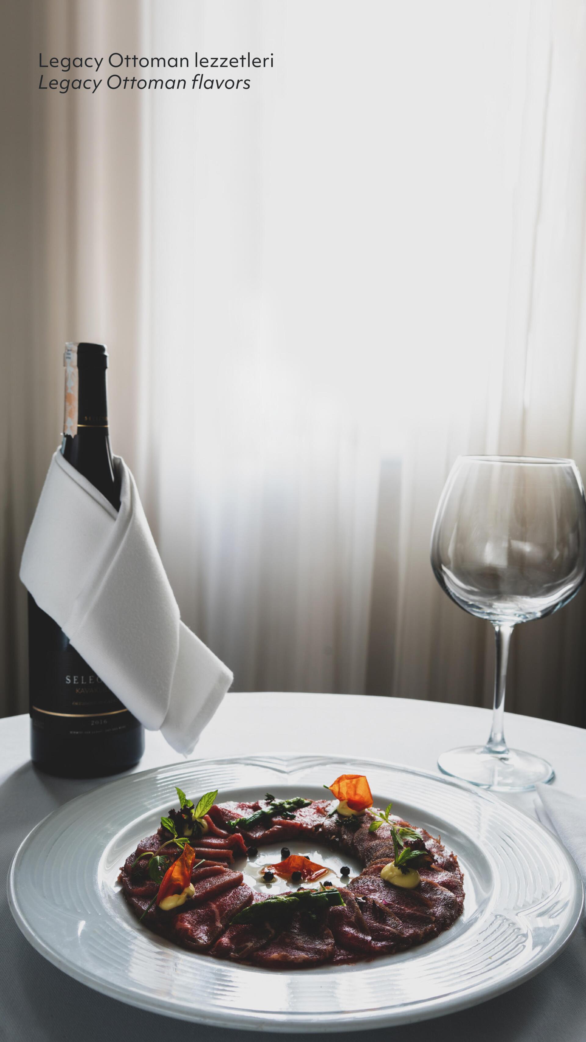 A plate of food and a glass of wine on a table.