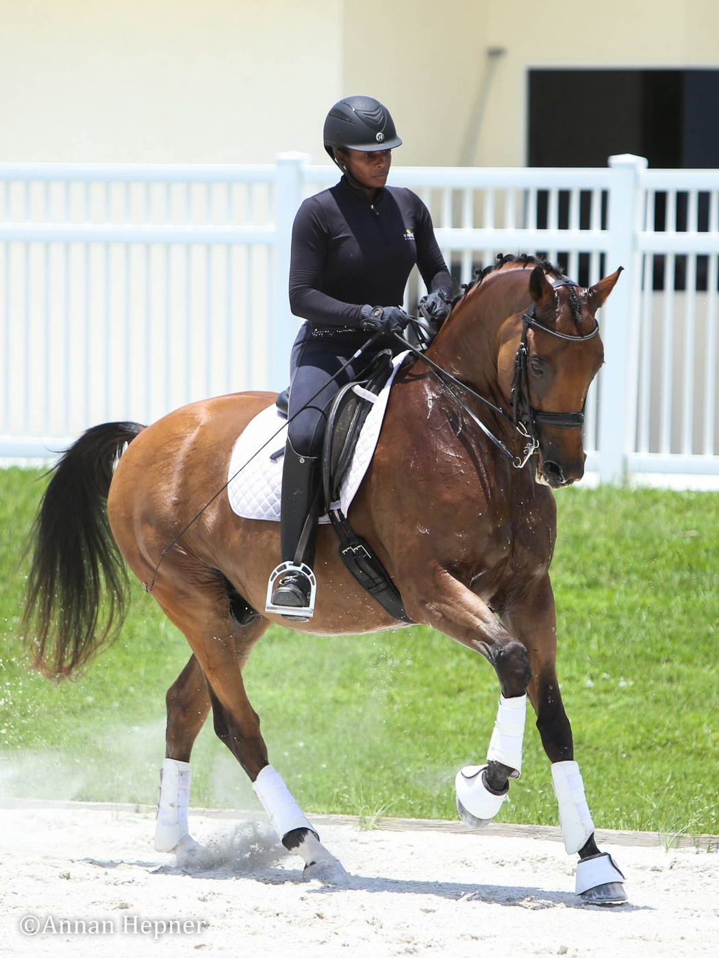 Mentor guiding a rider beside a horse in the arena