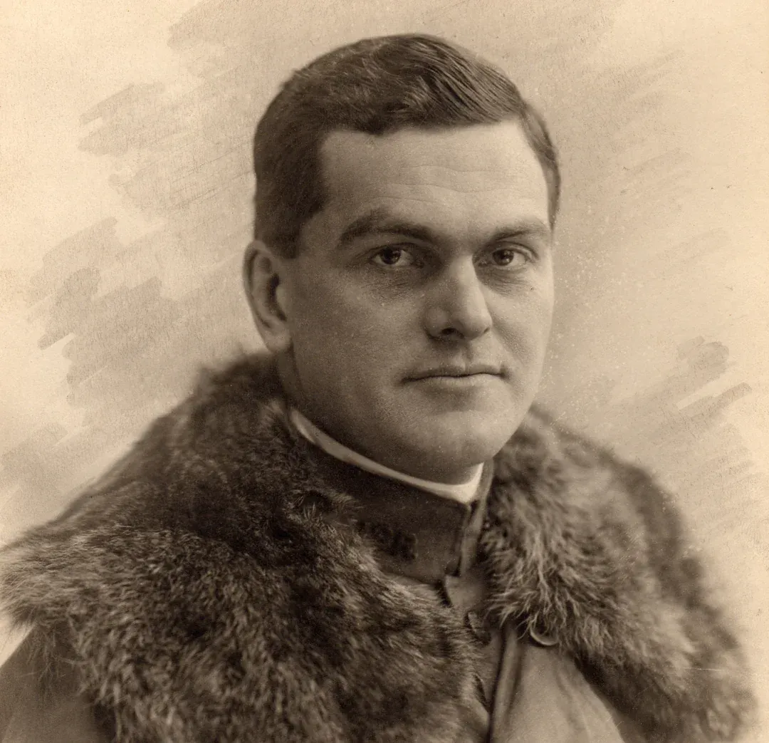Portrait of a man in a fur-trimmed coat, looking directly at the camera.
