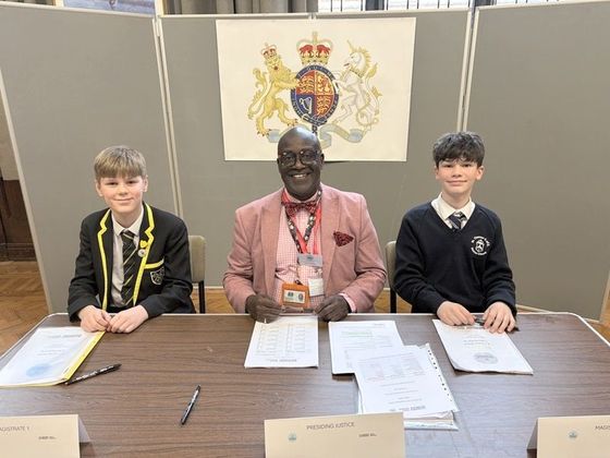 Two pupils acting as the Magistrates, assisted by one of the GM MIC team. © 2026 Stockport Grammar School
